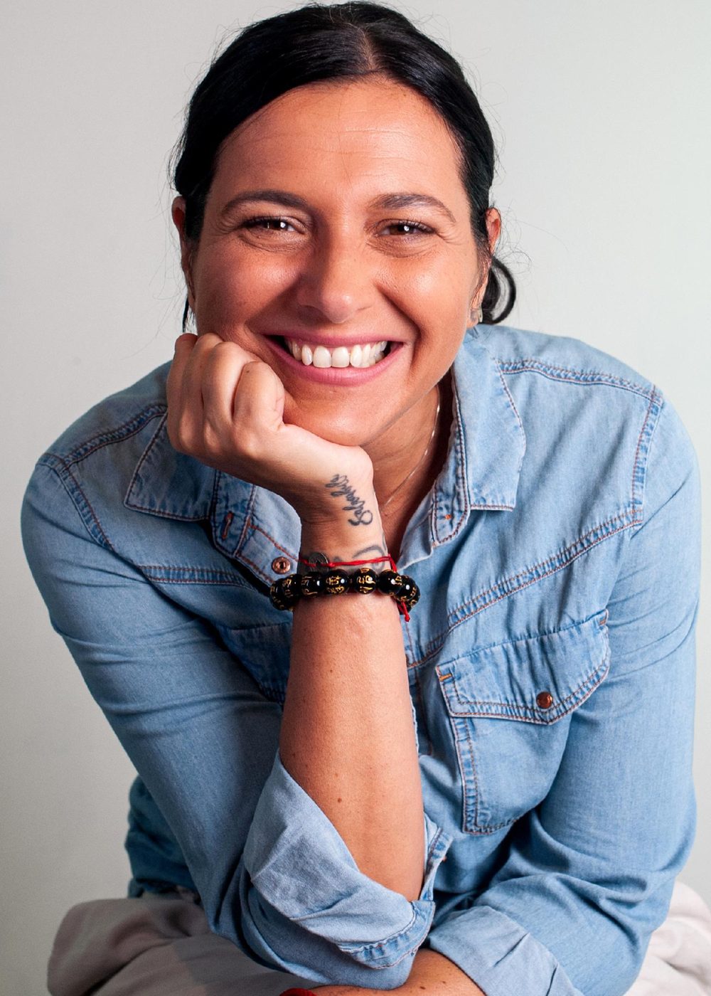 Ginny l'Astrologa sorride con il mento appoggiato alla mano